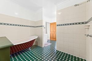 a bathroom with a tub and a green and white tiles at 58 Mystery Bay Road, Mystery Bay in Central Tilba +30 photos