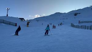 a group of people skiing down a snow covered slope at East Rock in Queenstown