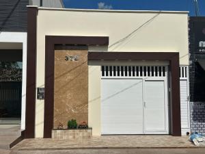 a white building with a white garage door at Casinha da Ana in Bacabal