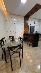a living room with a glass table and chairs at Casinha da Ana in Bacabal