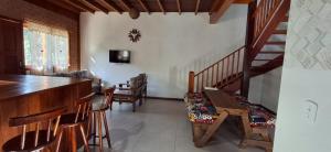 a living room with a staircase and a table and chairs at Recanto do Sol in Bocaina de Minas