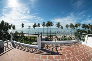 a balcony with a view of the beach and palm trees at Aloha Hotel Mũi Né in Ấp Thiện Sơn