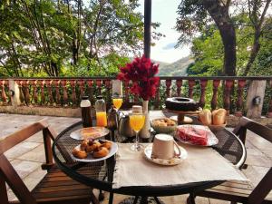 a table with food and orange juice and drinks on it at Chalé vista para Mata Itaipava in Araras Petropolis