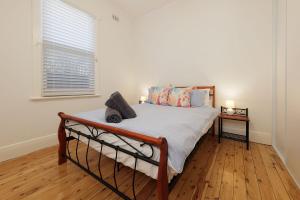 una camera da letto con un letto in una stanza con una finestra di 'Braeside'- Victoria St's Secret ad Albury