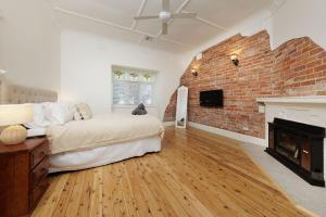un soggiorno con un letto e un muro di mattoni di 'Braeside'- Victoria St's Secret ad Albury