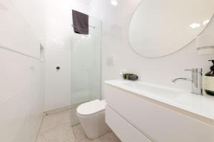 un bagno bianco con un water e un lavandino di 'Braeside'- Victoria St's Secret ad Albury Altre 9 foto