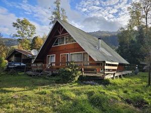 a large wooden house with a gambrel roof at Casa en Liquiñe in Liquiñe