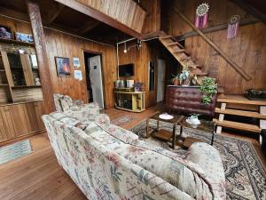 a living room with two couches and a staircase at Casa en Liquiñe in Liquiñe