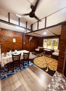 Una sala de estar con una mesa y sillas y un sofá. en Pondok Muara Chalet, en Pantai Cenang