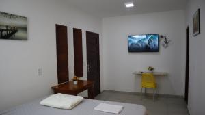 a bedroom with a bed and a desk with a yellow chair at Pousada Chácara Pau - Brasil in Lagoa Sêca