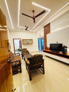 TurkapallyCorporate Hostel & PG的客厅配有椅子和吊扇