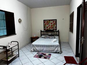 a bedroom with a bed and a tile floor at Recanto da Vovó in Santarém