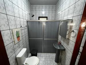 a bathroom with a shower and a toilet and a sink at Recanto da Vovó in Santarém