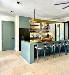 een keuken met een aanrecht met barkrukken bij La Cueva De Piedra in Puerto Morelos