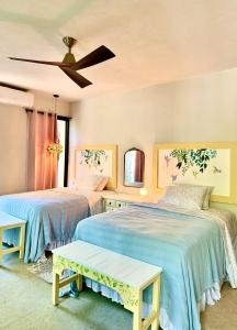een slaapkamer met twee bedden en een plafondventilator bij La Cueva De Piedra in Puerto Morelos