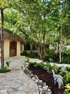 een tuin met een standbeeld van een hond in een tuin bij La Cueva De Piedra in Puerto Morelos