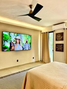 een slaapkamer met een flatscreen-tv aan de muur bij La Cueva De Piedra in Puerto Morelos