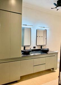 een badkamer met twee wastafels en twee spiegels bij La Cueva De Piedra in Puerto Morelos +31 foto's