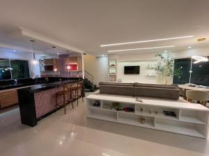 a large living room with a couch and a kitchen at Mansão em Itauna - Saquarema - Com piscina para ate 16 pessoas in Saquarema