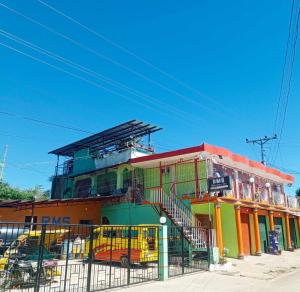 a colorful building with buses parked in front of it at RMS Travellers Inn in Camotes Islands