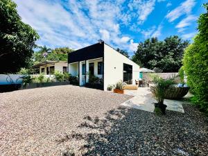a house with a gravel driveway in front of it at Villa Paz CASA QUINTA CON PISCINA PRIVADA in Ricaurte