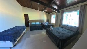 a bedroom with two beds and a couch in it at Mansão em Itauna - Saquarema - Com piscina para ate 16 pessoas in Saquarema +40 photos