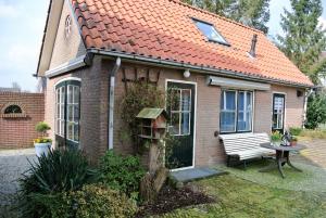 een klein bakstenen huis met een oranje dak bij B&B de Noordenberg in Holten