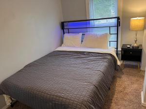 een slaapkamer met een groot bed, een nachtkastje en een raam bij Finger Lakes Apartment in Hornell