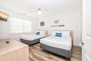 a bedroom with two beds and a ceiling fan at Serenity is Yours Oceanfront Pool SP2 in Myrtle Beach