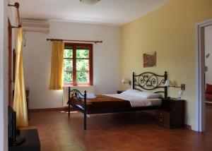 una camera da letto con un letto e una finestra di Ikaria Utopia - Cusco Studios a Evdilos