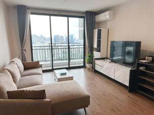 a living room with a couch and a large window at Artisan Ratchada Spacious 2BR Condos in Bangkok