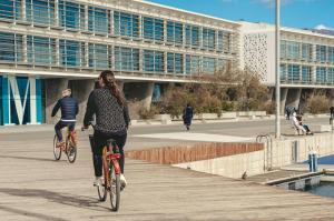 バレンシアにあるAPARTAMENTO PLAYA Valenciaの建物の前の遊歩道で自転車に乗っている二人