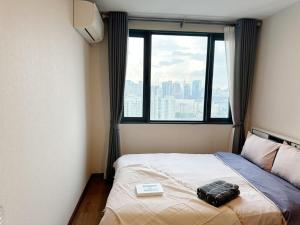 a bed in a room with a large window at Artisan Ratchada Spacious 2BR Condos in Bangkok