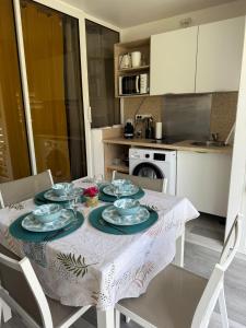 a table with plates and bowls on it in a kitchen at Studio Les Alizés du soir St François Rés Anse des rochers équipé avec citerne d'eau in Saint-François