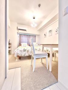 a white bedroom with a bed and a chair at 29Nooks ナチュラル in Nagoya