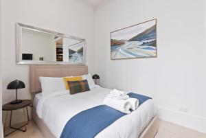 a bedroom with a white bed and a window at slick city apartment in Auckland +15 photos