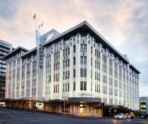 a large white building on the corner of a street at slick city apartment in Auckland