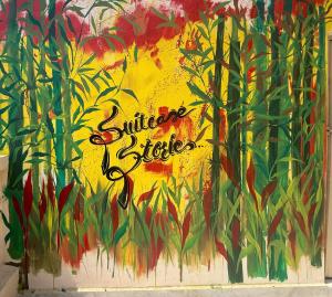 a painting of flowers on the side of a wall at Suitcase Stories in Kolkata