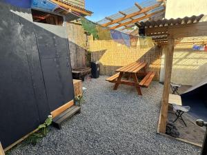 a patio with a wooden picnic table and a fence at Hospedaje Centrico pv in Puerto Varas