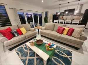 a living room with two couches and a table at Luxury Beachside Home in Maninoa