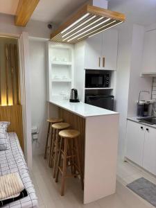 マニラにあるCozy Escape at The Avenueの部屋にカウンターとスツールがあるキッチン