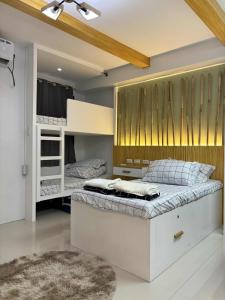 マニラにあるCozy Escape at The Avenueのベッドルーム1室(二段ベッド2台、ラグ付)