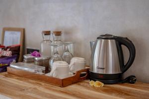 una macchinetta del caffè seduta sopra un tavolo di legno di Golden Garuda Cottages at Diamond Beach Hills a Nusa Penida