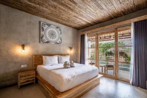 a bedroom with a bed and a large window at Golden Garuda Cottages at Diamond Beach Hills in Nusa Penida +25 photos