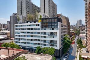 um grande edifício branco numa cidade com edifícios altos em Corazón Stgo Estilo Puro em Santiago