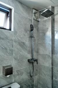 a shower with a shower head in a bathroom at De'Mei House in Hanoi +55 photos