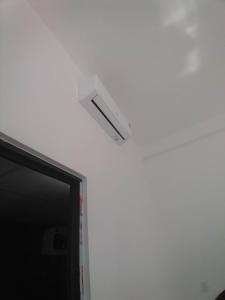 a light on top of a white wall next to a door at Căn hộ H in Kon Rung (1)