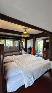 a large bedroom with a large bed with a chandelier at Boon Homestay & Cafe บุญโฮมสเตย์ in Ban Buak Khang