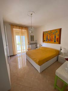 a bedroom with a bed with a yellow bedspread at Skyline Appartamento Lella in Acqui Terme