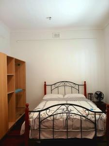 a bedroom with a bed and a white wall at Cozy and Peaceful home surrounding by cafes and restaurants in Perth
